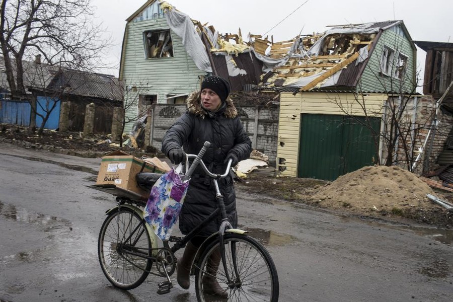 Sau chuỗi ngày Quân đội chính phủ và ly khai bắn phá, "nồi hơi" Debaltsevo trở nên hoang tàn. Bà lão dắt xe đạp ngang qua căn nhà bị tàn phá nặng nề ở  thị trấn Debaltsevo ngày 13/3.